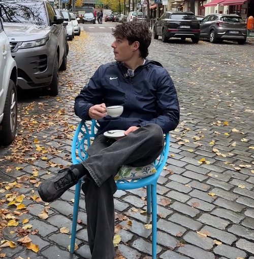 Jakob Zimmer sitzt mit einer Tasse Kaffee auf der Sraße